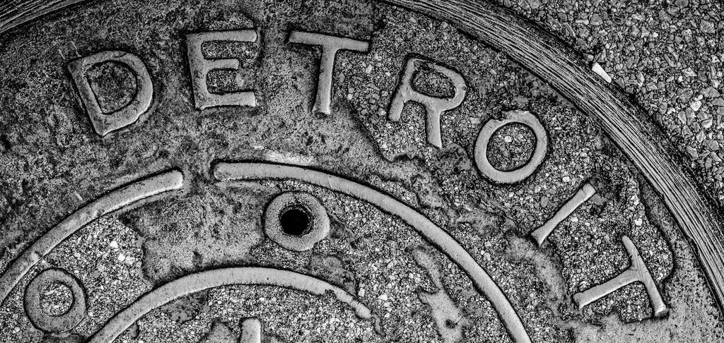 Image of a Detroit manhole cover, close-up and worn