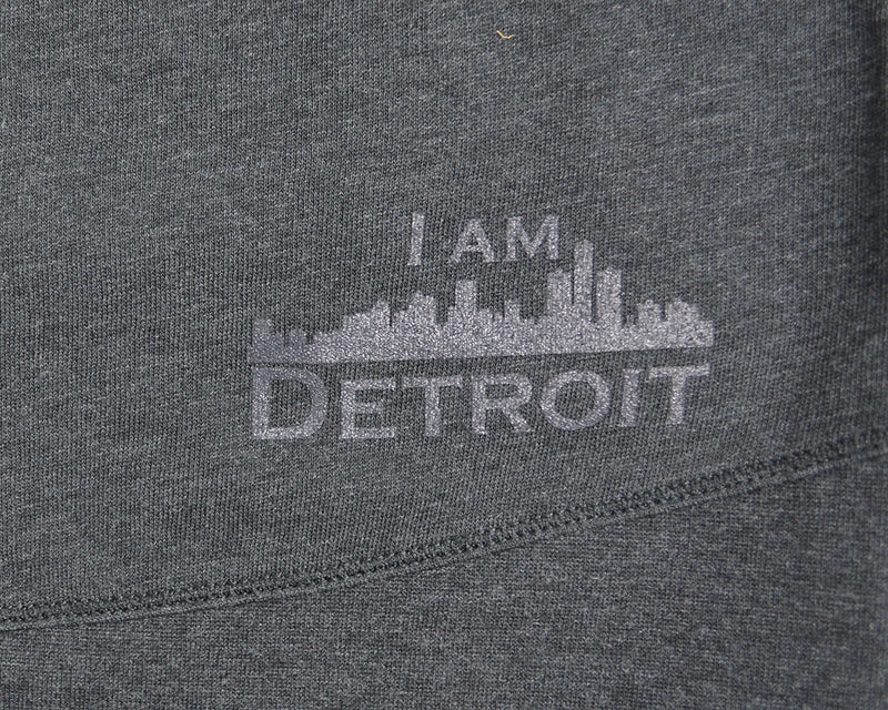 Close up of I Am Detroit logo near hem at bottom on the back of hooded sweatshirt 